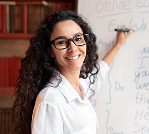 Woman writing on whiteboard, smiling
