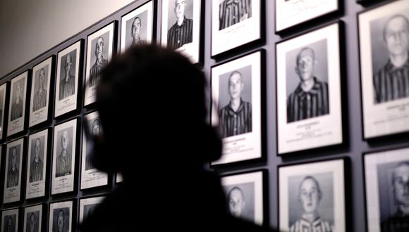 visitor with headset looking at photos of holocaust victims