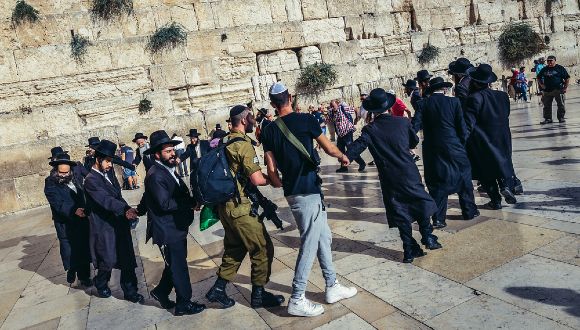 ultra_orthodox men dancing with soldiers at the kotel