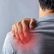 person touching his back where he experiences pain